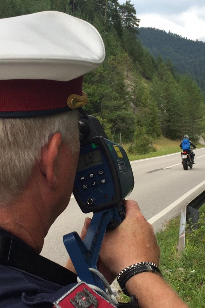 Ein Polizist misst die Geschwindigkeit eines Motorradfahrers.