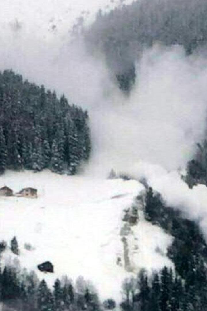 Eine Lawine geht in einem verschneiten Berggebiet nieder.