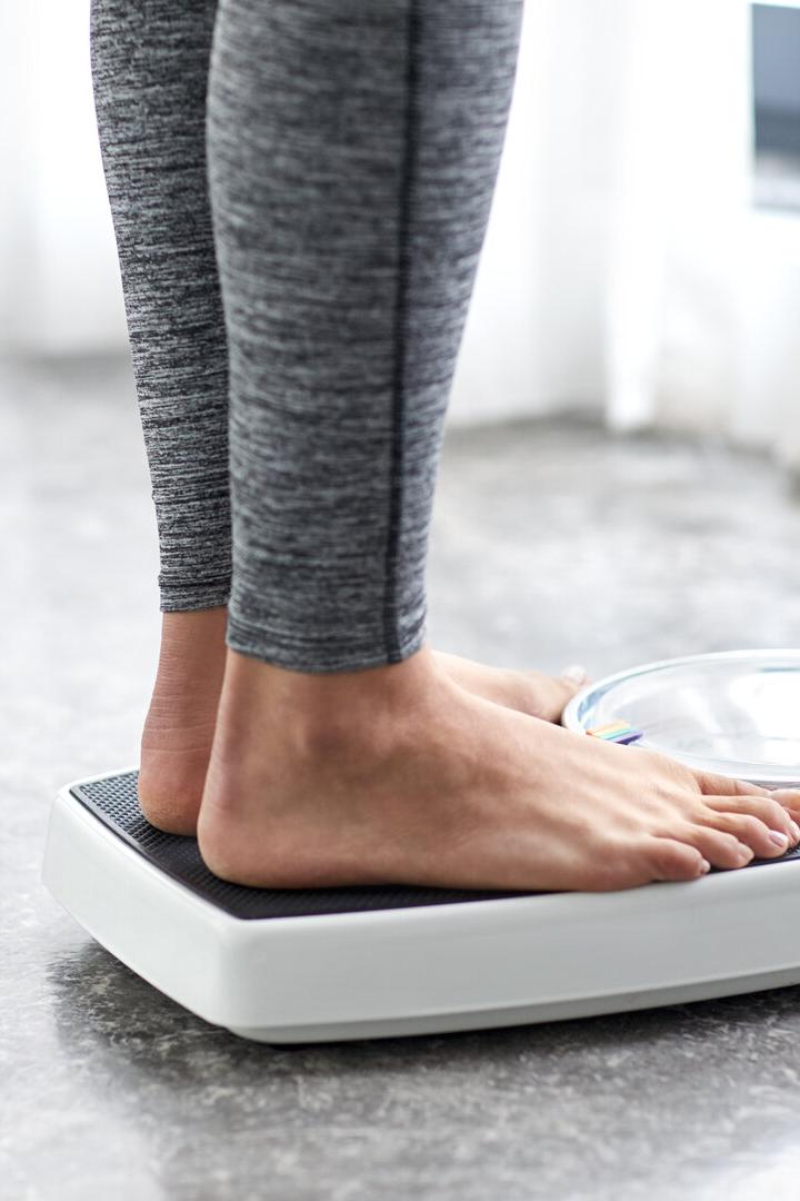 Das Bild zeigt zwei Füße einer Frau auf einer Waage.