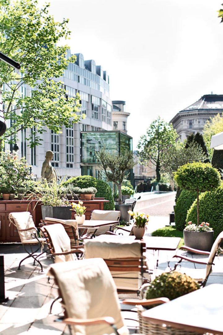 Einladende Terrasse eines Cafés mit Tischen und Stühlen im Freien.