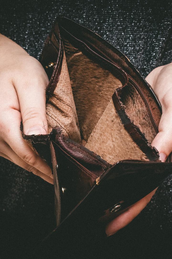 Old empty wallet in the hands .Vintage empty purse in hands of women . Poverty concept, Retirement. Special toning