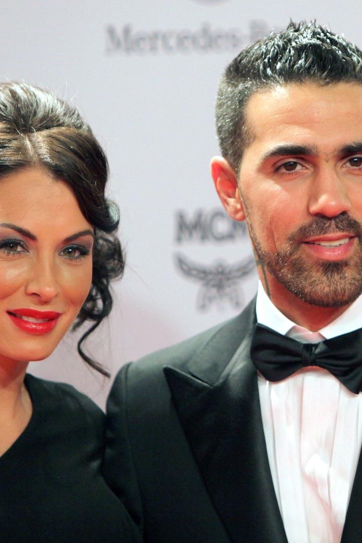 Bushido und seine Frau auf dem roten Teppich vor einer weiß-schwarzen Werbewand.