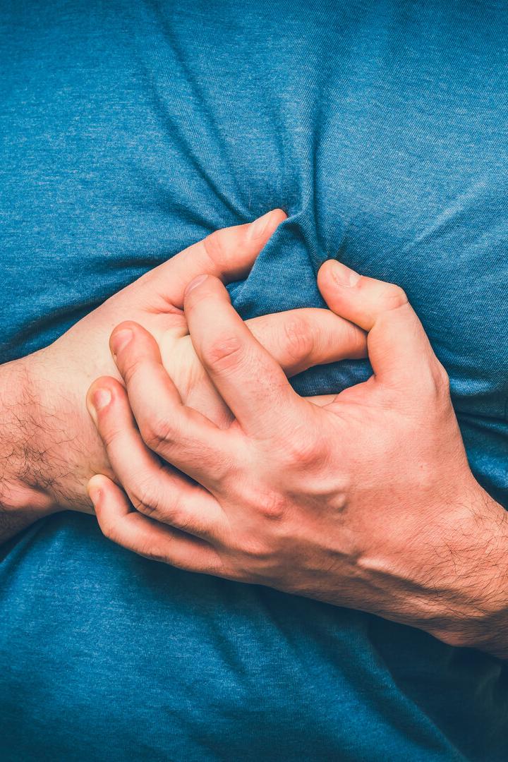 Ein Mann greift sich zum Herzen. 