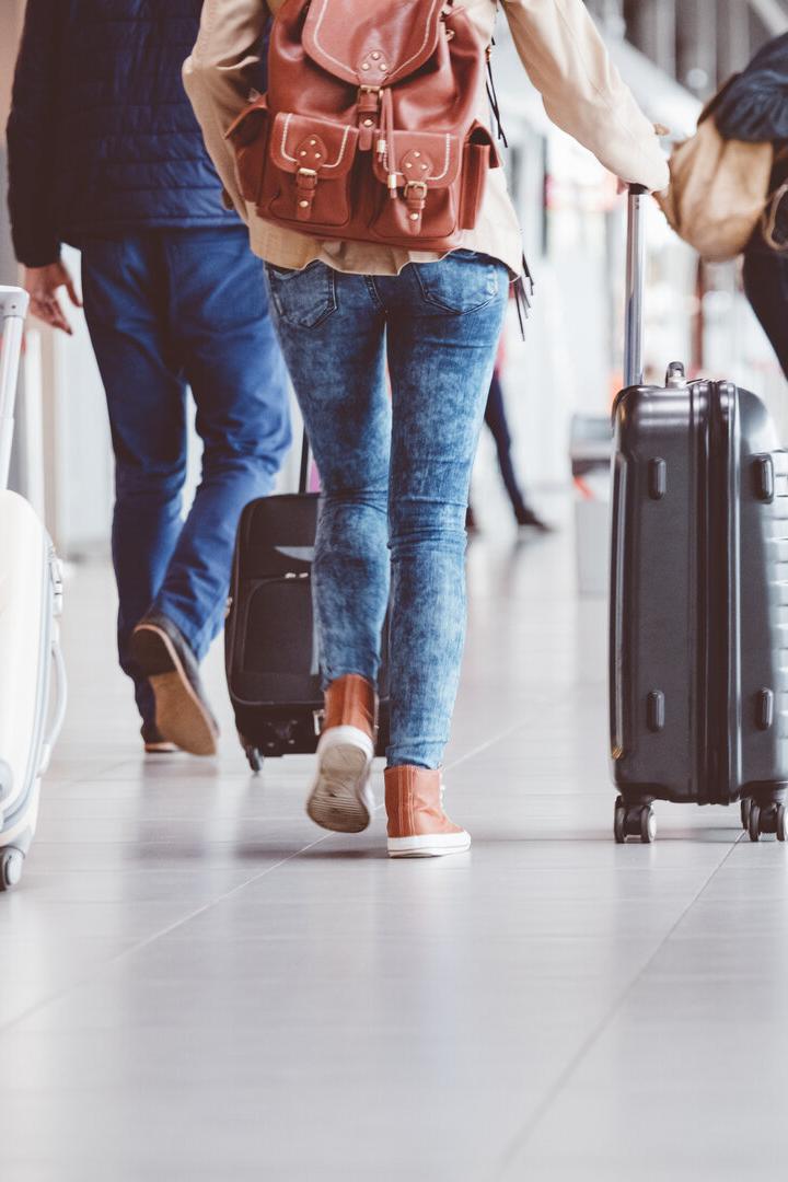Passagiere gehen im Flughafenterminal entlang.