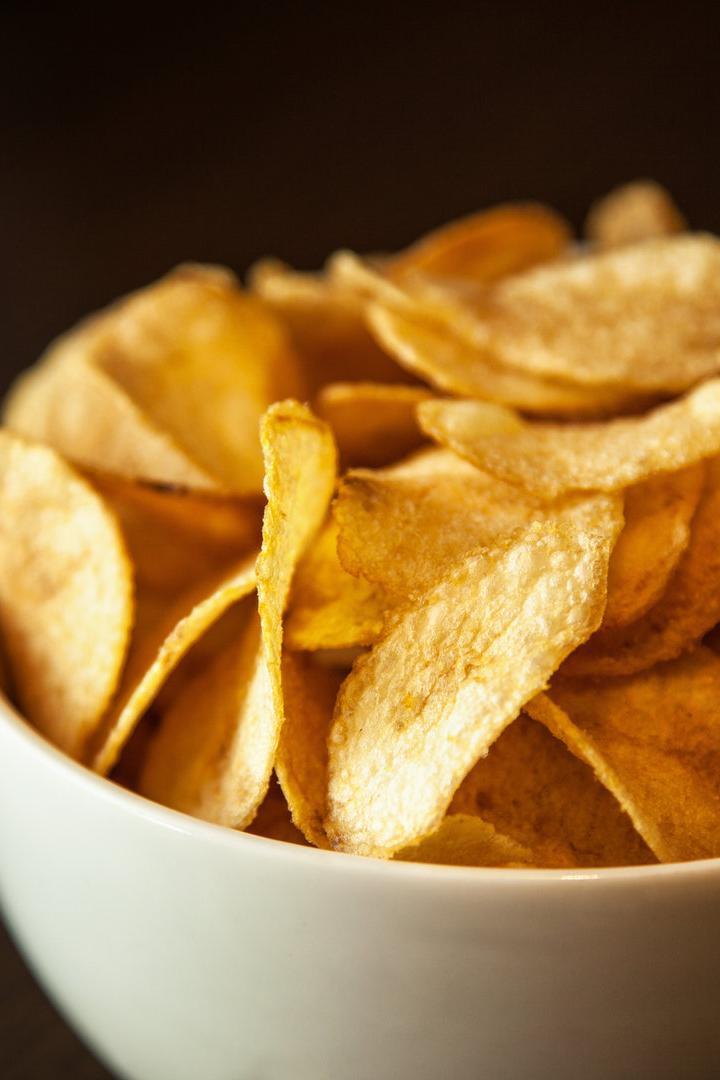 Eine Schüssel ist gefüllt mit goldgelben Kartoffelchips.
