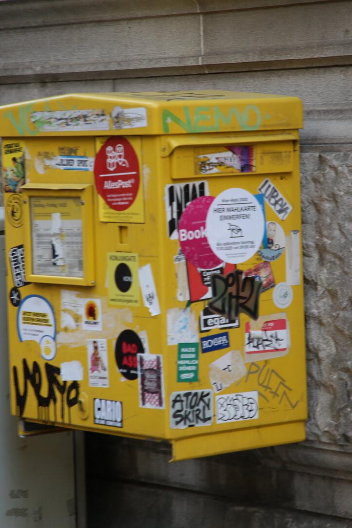 Ein mit vielen Pickerl beklebter Briefkasten in Wien. 