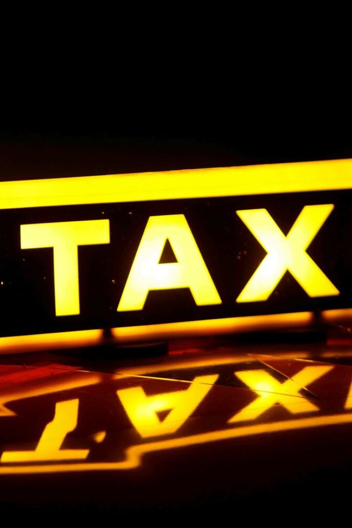 Ein gelbes Taxi-Schild leuchtet im Dunkeln.