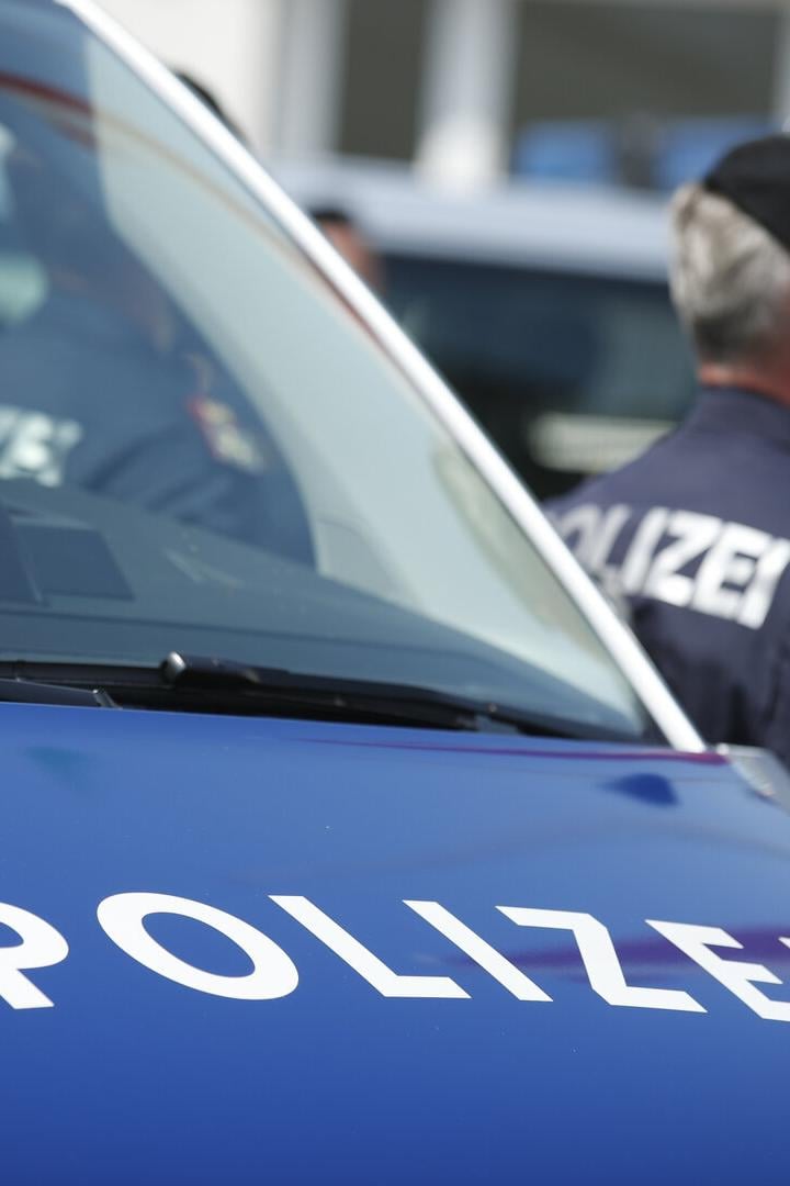 Eine Polizistin steht neben einem Polizeiauto.