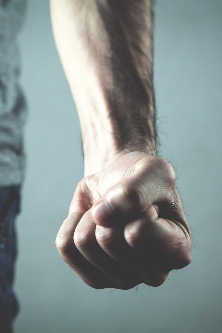 Eine geballte Faust vor einem grauen Hintergrund.