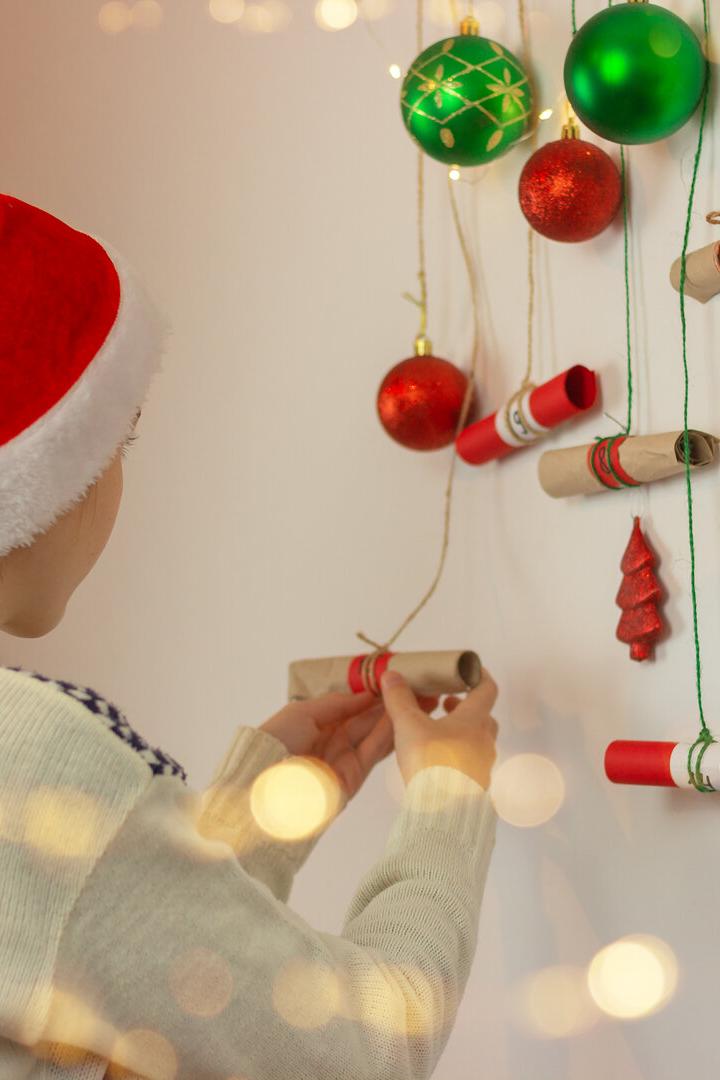 Ein Mädchen öffnet ein Kästchen bei einem Adventkalender.