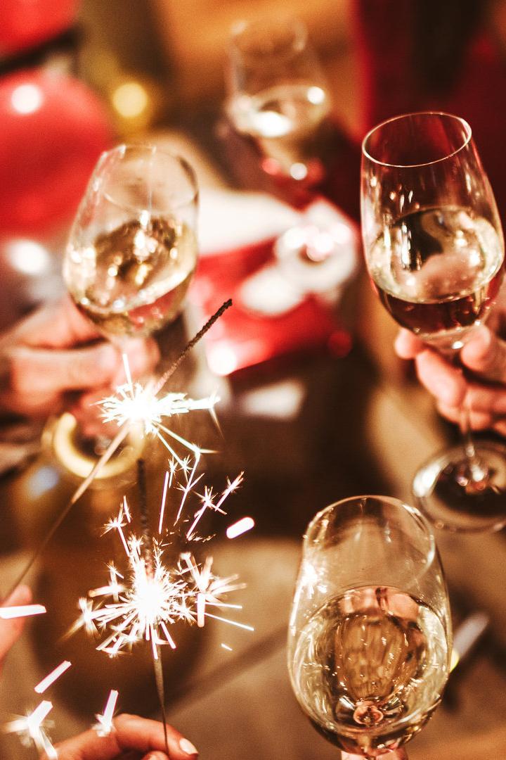 Menschen feiern mit Sektgläsern und Wunderkerzen.