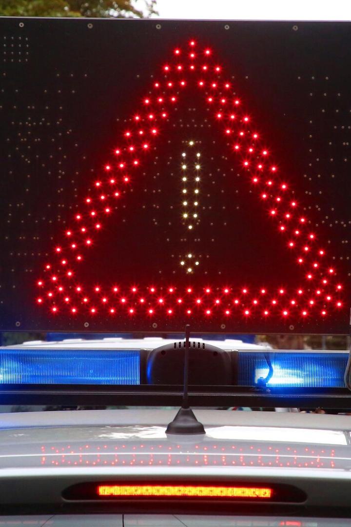 Ein Warnschild mit einem roten Dreieck und Ausrufezeichen auf dem Dach eines Fahrzeugs.