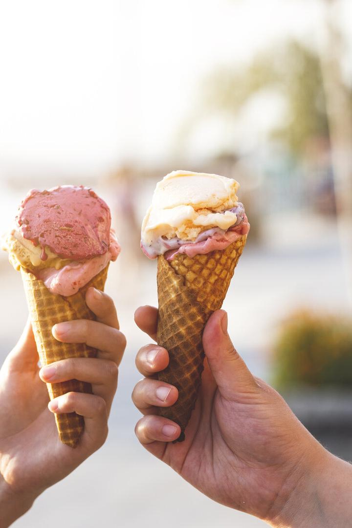 Zwei Hände halten je eine Waffel mit Eis in verschiedenen Geschmacksrichtungen.
