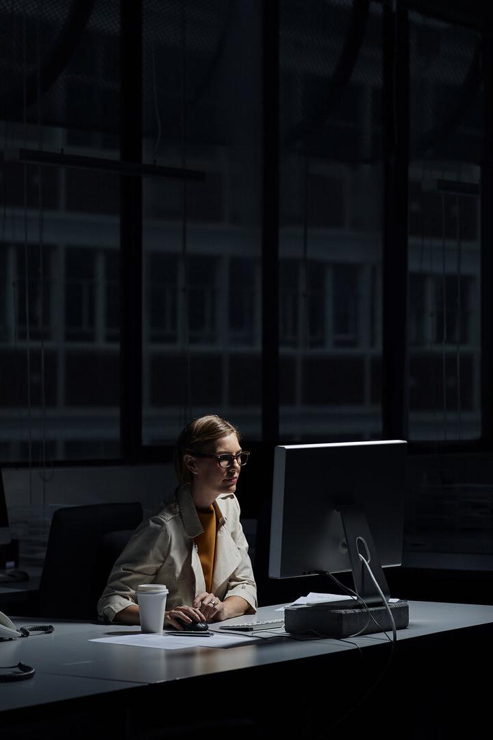 Businesswoman using computer in dark office