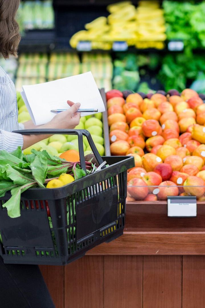 Frau kauft mit Korb ein