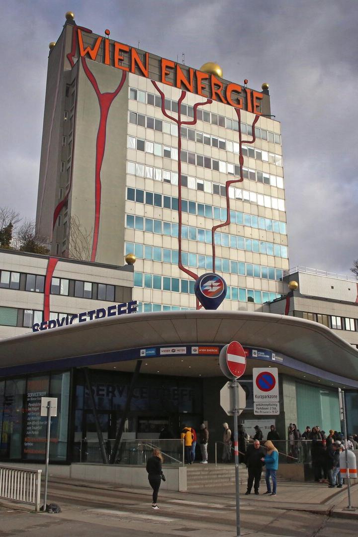 Das Wien Energie-Gebäude mit roter Dekoration und dem Schriftzug "WIEN ENERGIE" überragt den Eingangsbereich.
