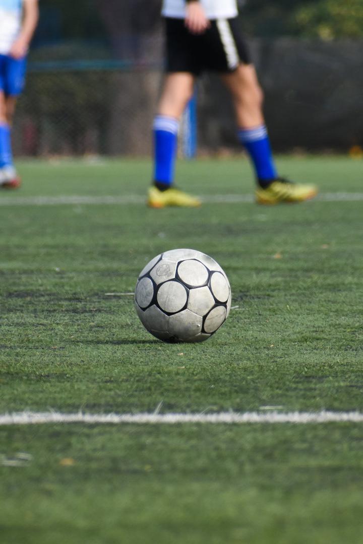 Ein Fußball liegt auf einem grünen Spielfeld.