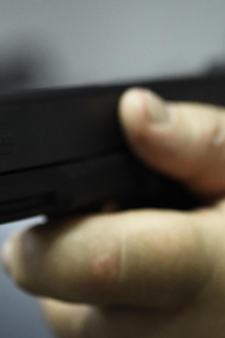 Schusswaffe wird von einer Hand gehalten.