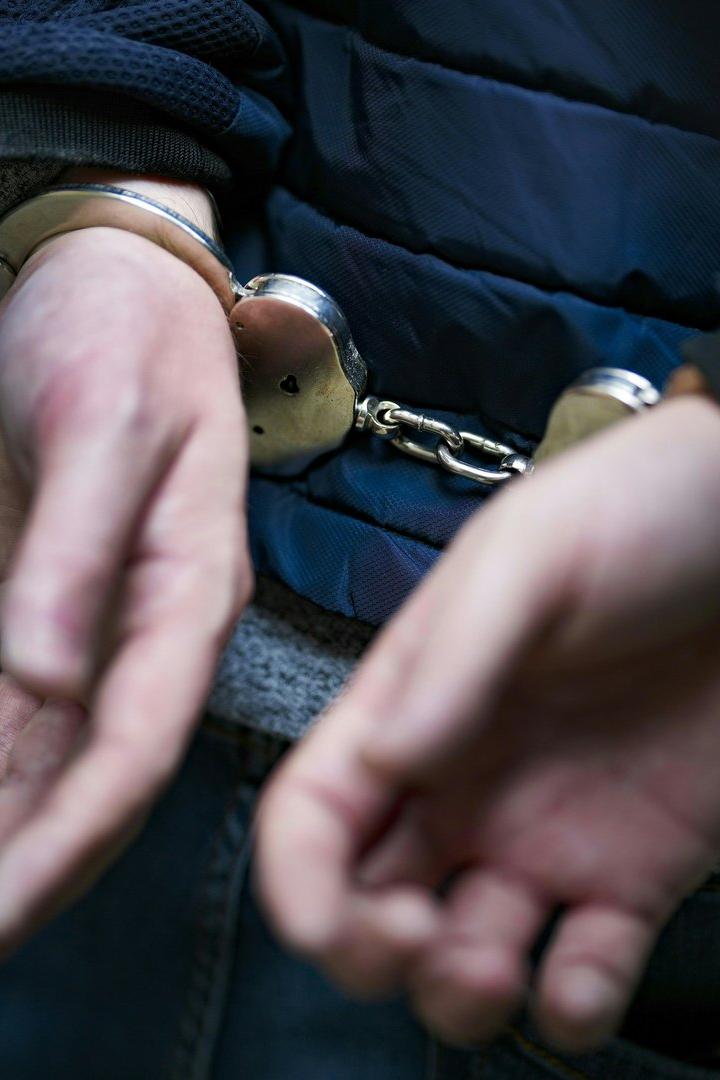 Ein Mann mit Handschellen auf dem Rücken.