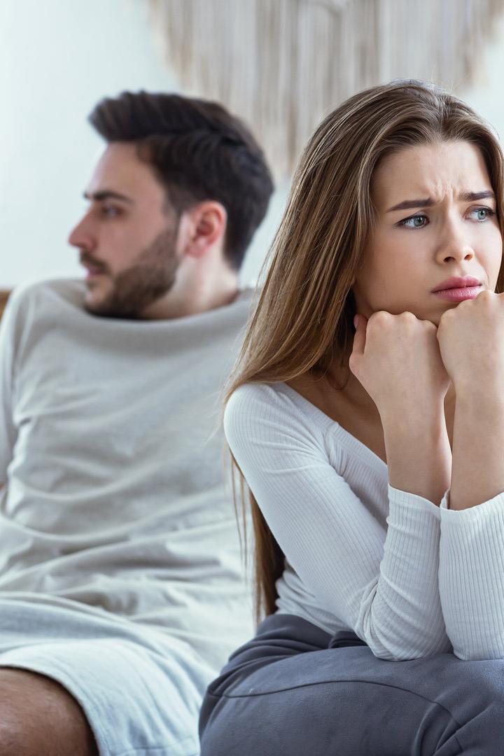 Mann und Frau auf dem Bett, weggedreht, Streit