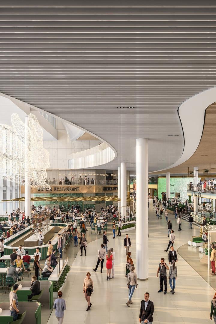 Innenansicht des Flughafens Wien mit Restaurants und wartenden Passagieren.