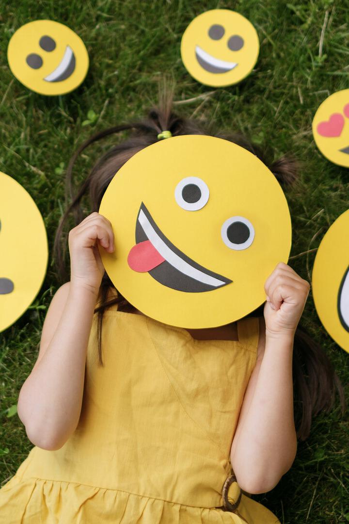 Eine Frau hält ein Schild mit Smiley-Gesicht hoch.