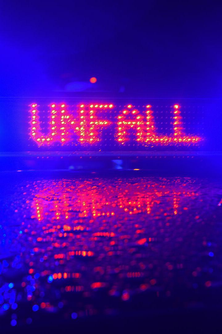 Blaulicht und Unfall-Schild auf Polizeiauto.