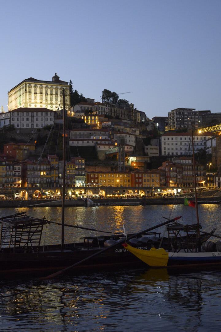 Porto bei Nacht, kleine Boote auf dem Douro im Vordergrund, Blick auf die beleuchtete Brücke Ponte Dom Luis I