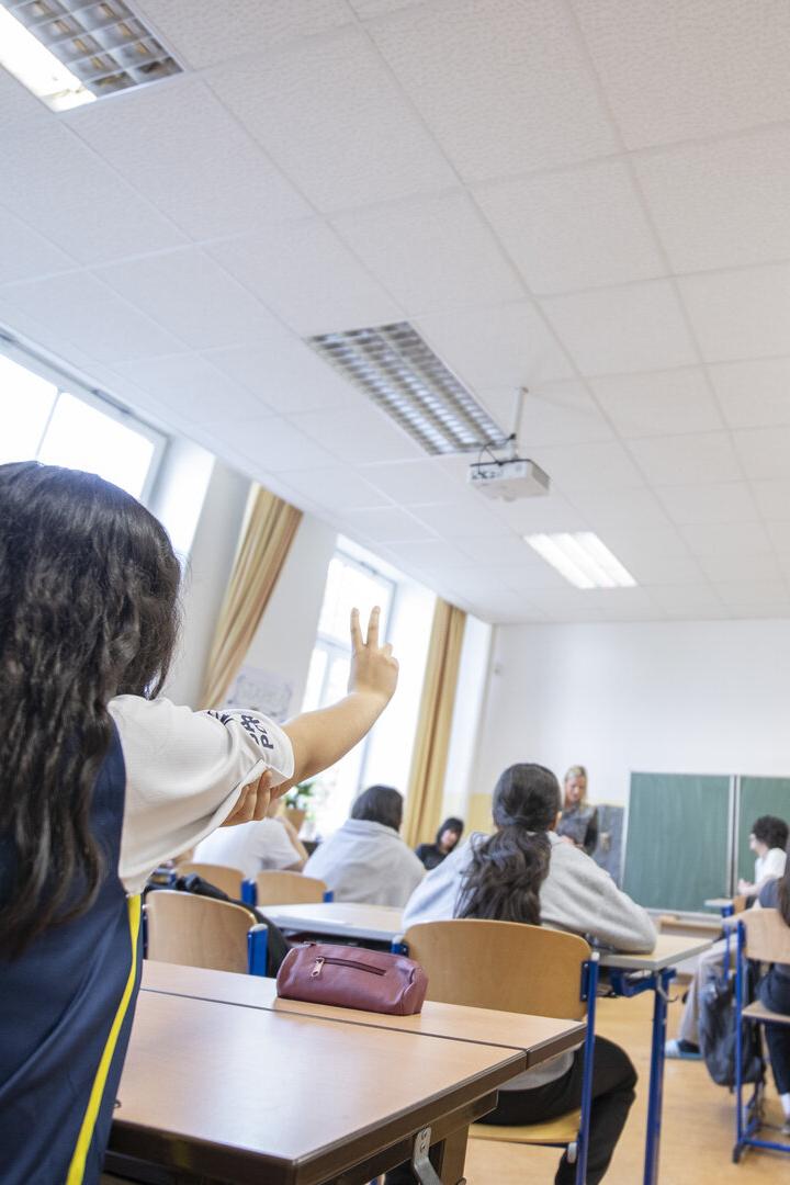 Eine Schülerin meldet sich im Klassenzimmer.