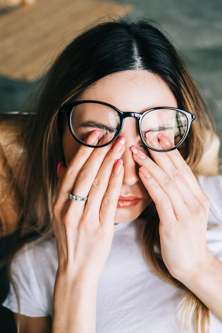 Frau wirkt erschöpft und reibt sich die Augen.