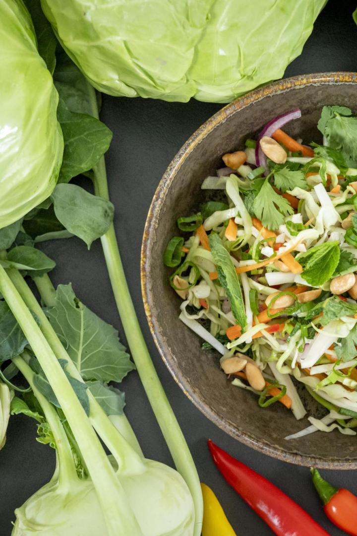 Coleslaw-Salat in einer braunen Schüssel mit Kohl und Kohlrabi rundum