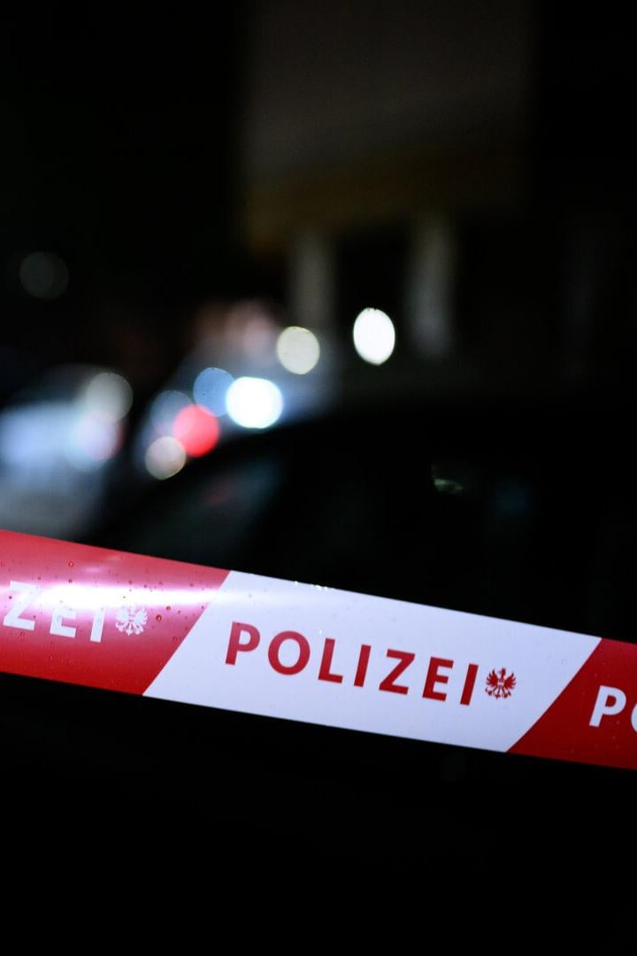 Ein rot-weißes Polizei-Absperrband ist im Dunkeln gespannt, im Hintergrund sind Lichter zu sehen.