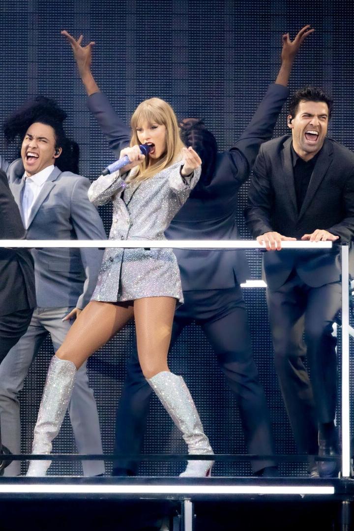 Taylor Swift auf einem Podium, umringt von Tänzern