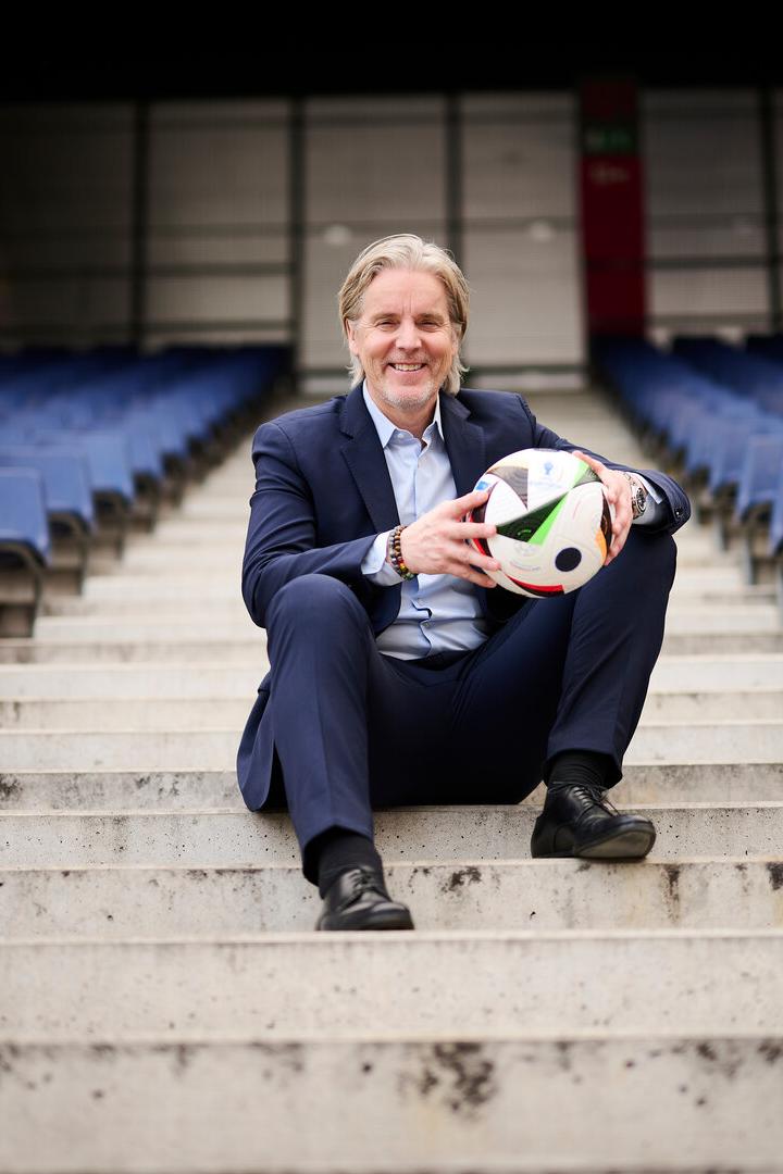 Jan Age Fjörtoft hält auf den Stufen der Tribüne einen Ball.