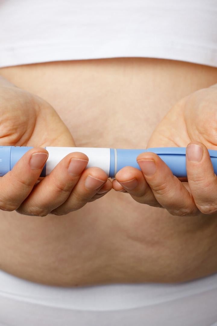 Eine Frau hält eine Abnehmspritze in der Hand.