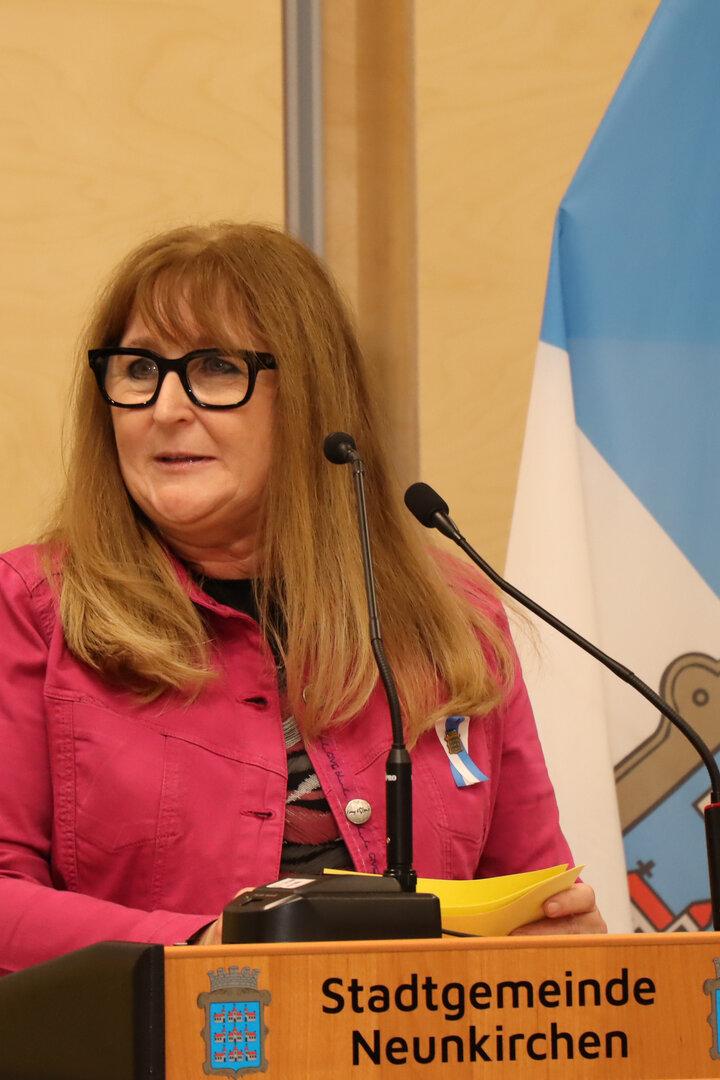 Eine Frau mit Brille steht am Rednerpult der Stadtgemeinde Neunkirchen.