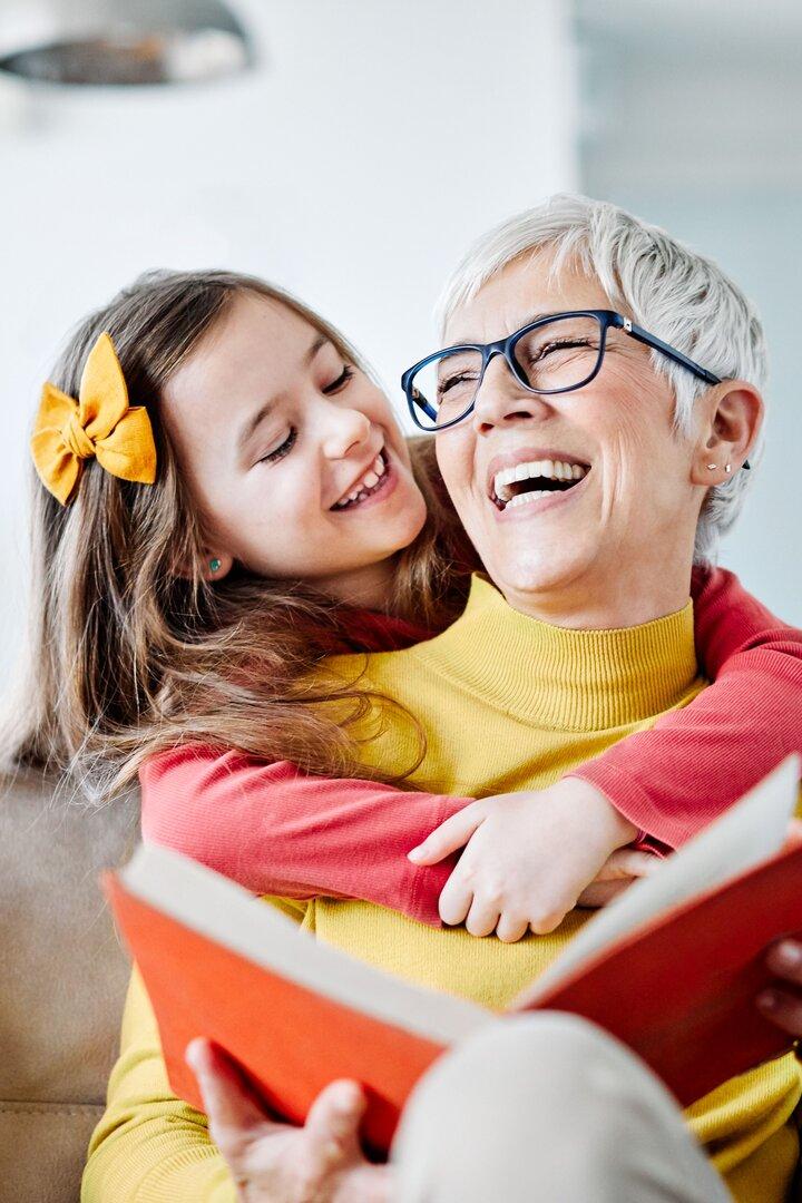 Eine Großmutter liest mit ihrem Kind ein Buch.