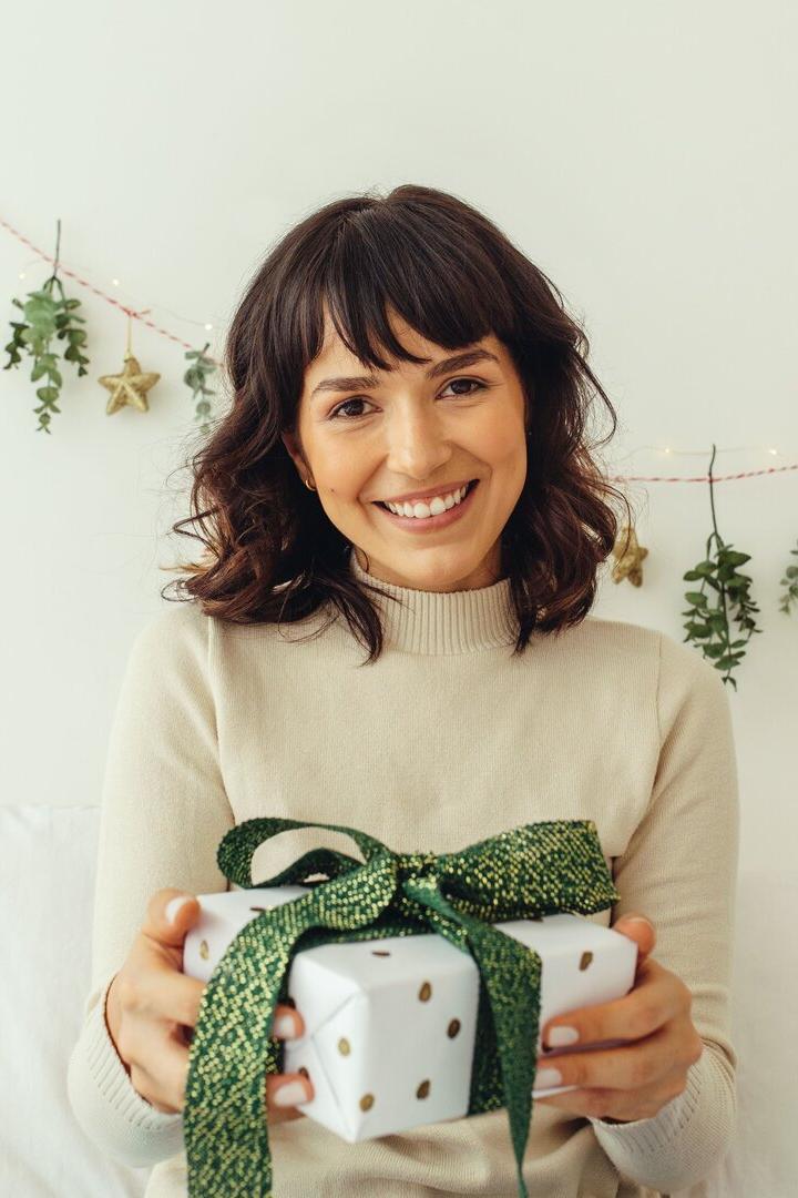 Frau mit einem Weihnachtsgeschenk in der Hand