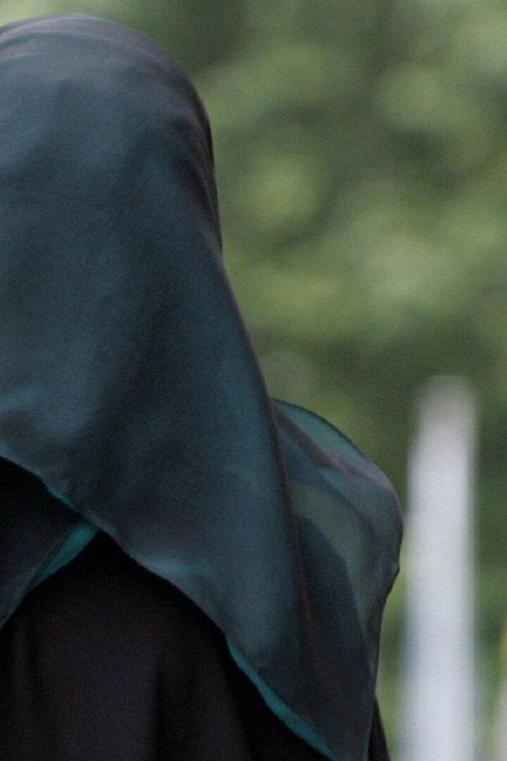 Eine Frau mit dunklem Hijab, von hinten gesehen.
