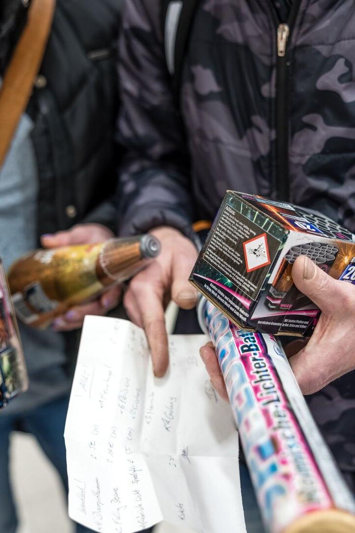 Menschen haben Silvesterböller in der Hand.