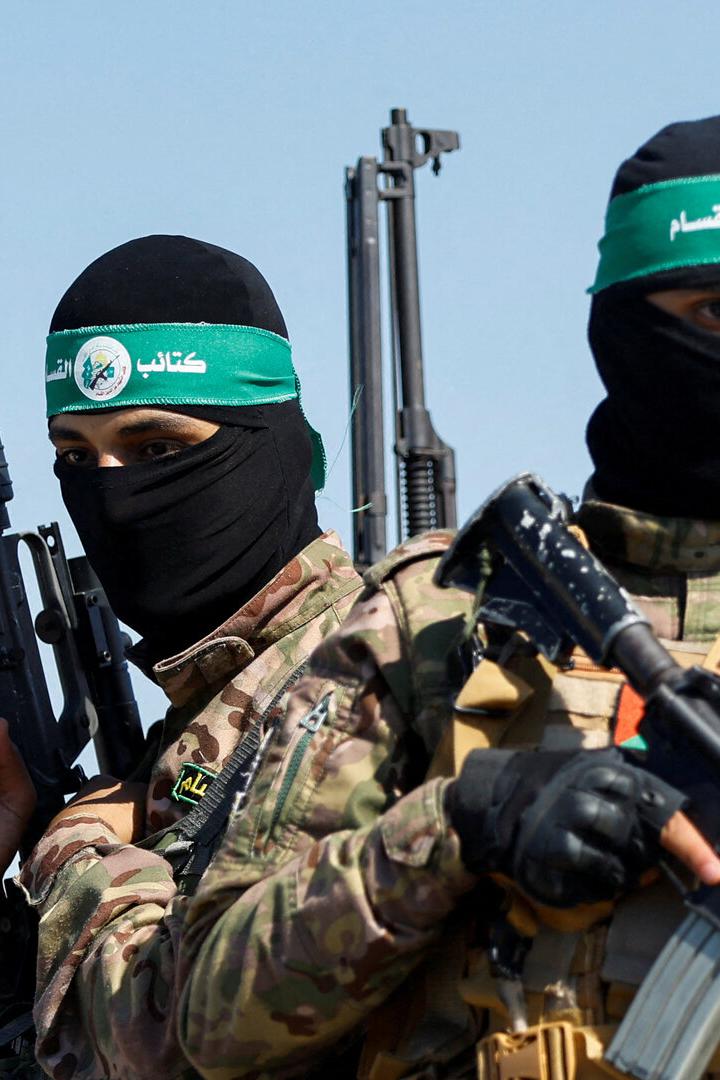 Zwei maskierte Männer in Militärkleidung tragen Gewehre und Stirnbänder.