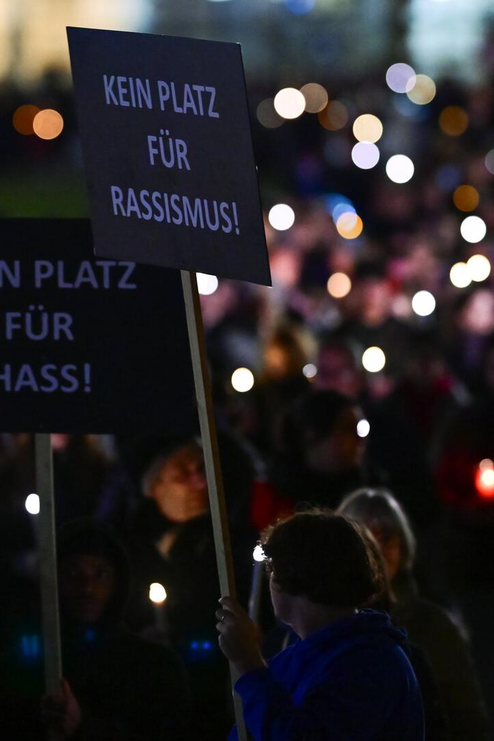 Menschen demonstrieren mit Schildern „Kein Platz für Hass!“ und „Kein Platz für Rassismus!“.