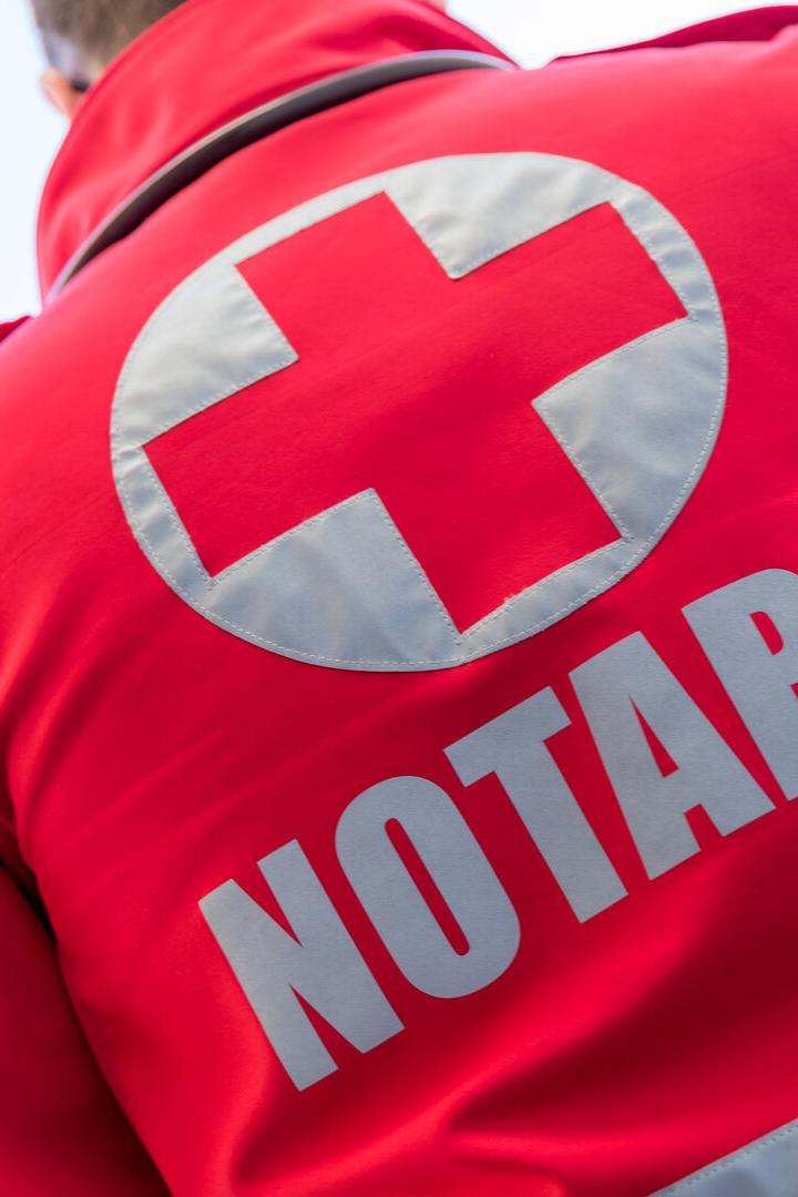 Ein roter Notarzt-Anzug mit einem weißen Kreuz ist von hinten zu sehen.