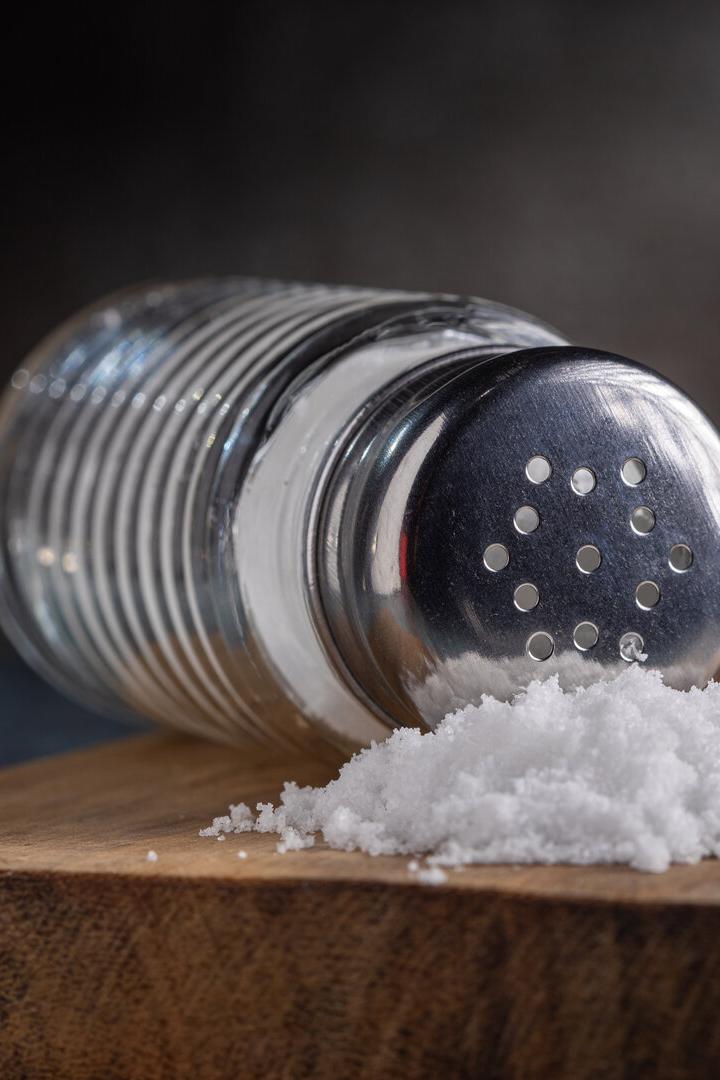 Ein umgefallener Salzstreuer liegt auf einem Tisch.