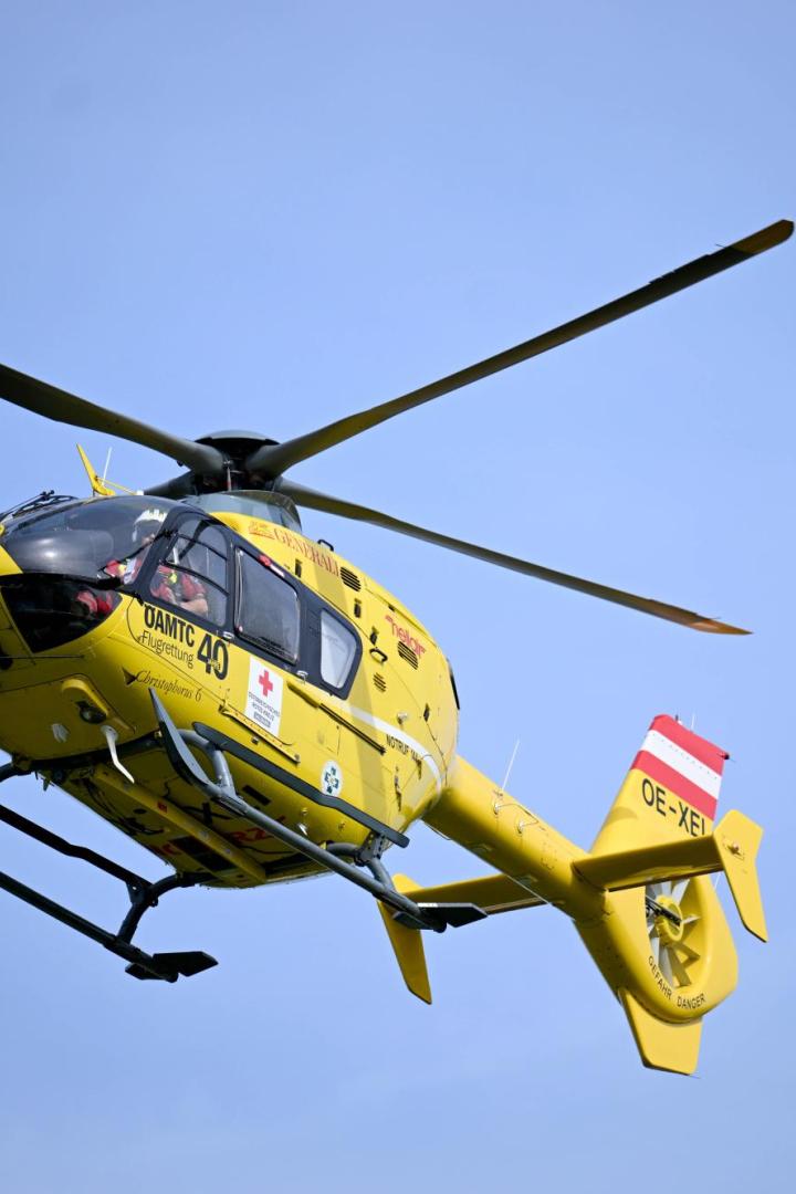 Ein gelber Notarzthubschrauber des ÖAMTC im Flug.