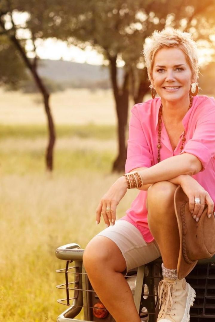Inka Bause sitzt in einem pinken Top und kurzen Hosen auf einem Jeep 