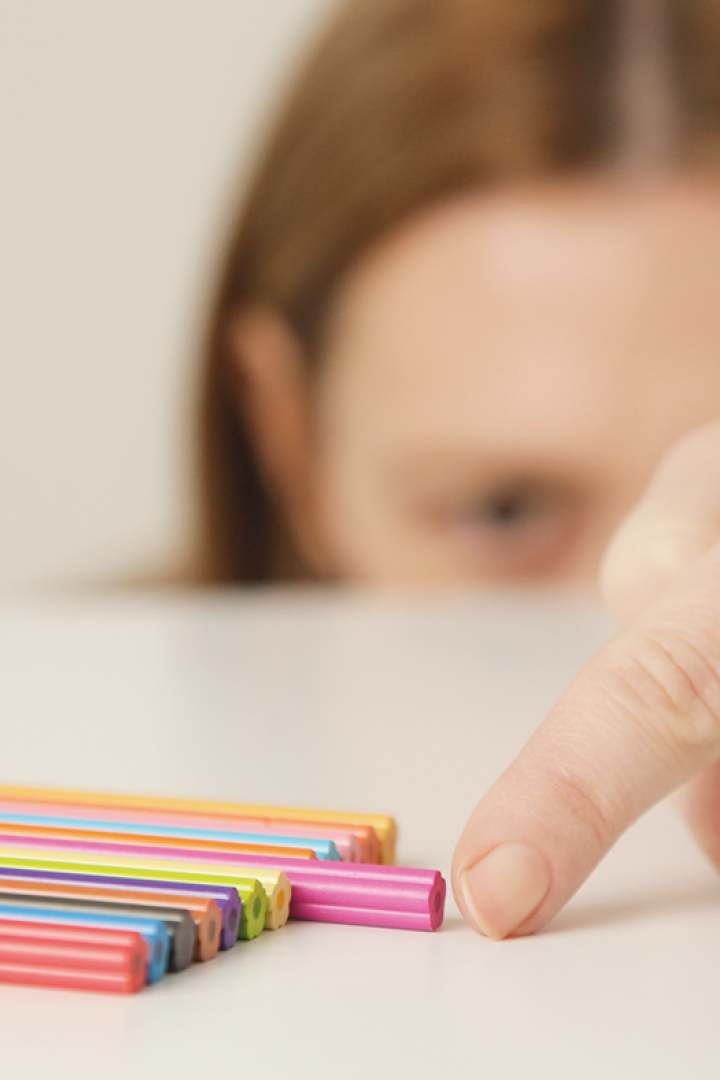 Frau, die einen Stift verschiebt, damit er optisch gleich aufgereiht ist, wie die anderen