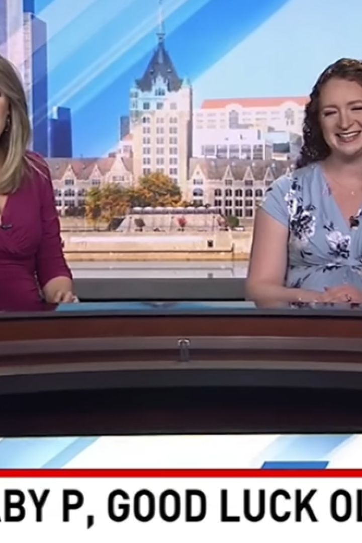 Zwei Fernsehmoderatorinnen stehen hinter einem Pult und lächeln
