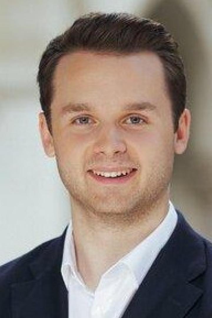 Harald Zierfuß von der ÖVP Wien posiert mit verschränkten Armen vor einem Gebäude.