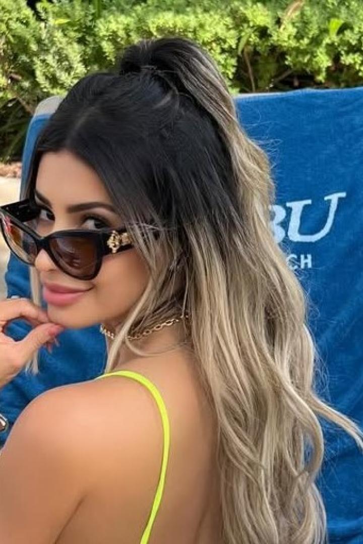 Die 35-jährige Influencerin Janaina Prazeres posiert mit Sonnenbrille auf einer Sonnenliege